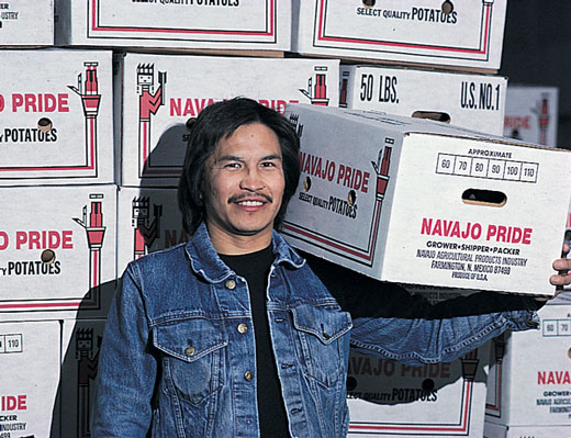 Man carrying a box that says 'Navajo Pride' on it.