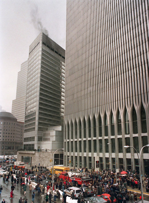 A crowd near the World Trade Center, with smoke rising from a tower.