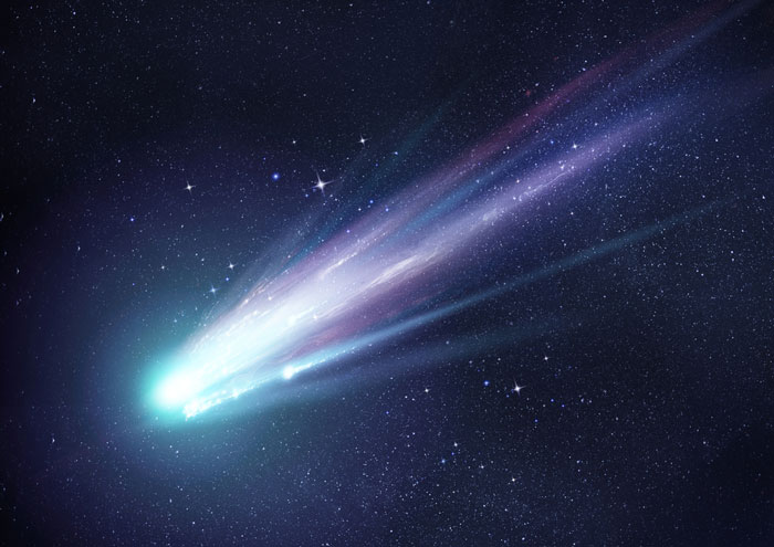 Comet with a long tail streaking behind it.