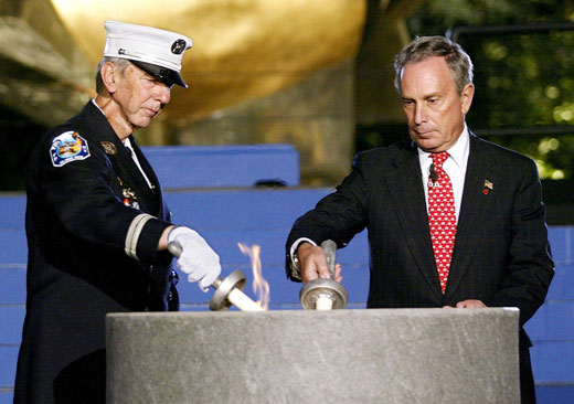 Mayor Michael Blumberg and a fireman light an eternal flame.