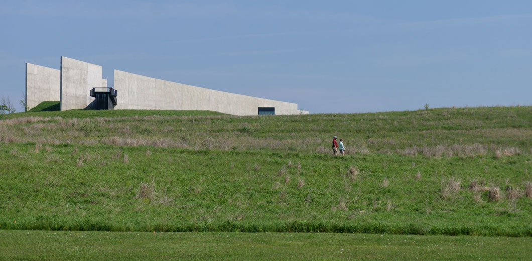 A concrete wall in a grassy field. 