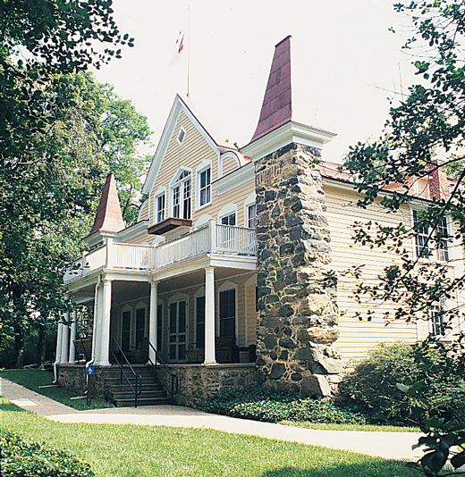 Yellow house with stone chimney.