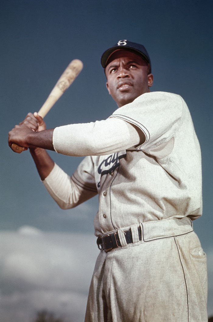 Baseball player Jackie Robinson swinging a bat.
