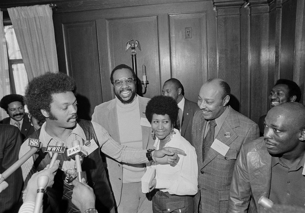 A group of people, including Aretha Franklin and Reverend Jesse Jackson.