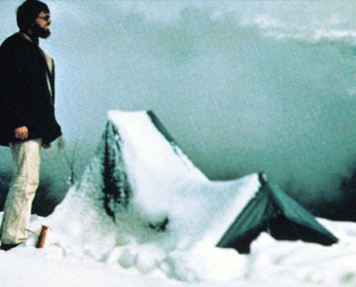 Scientist David A. Johnston standing near a tent covered with snow.