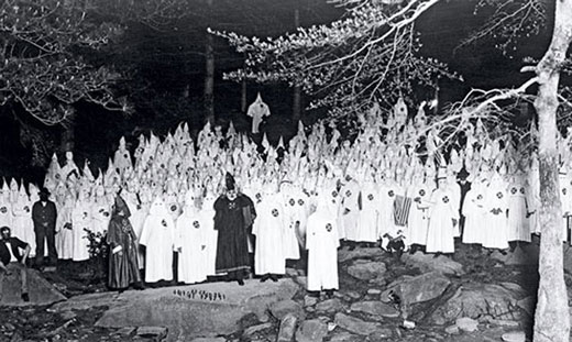 Gathering of Klan members wearing their traditional white robes and pointed hats. 