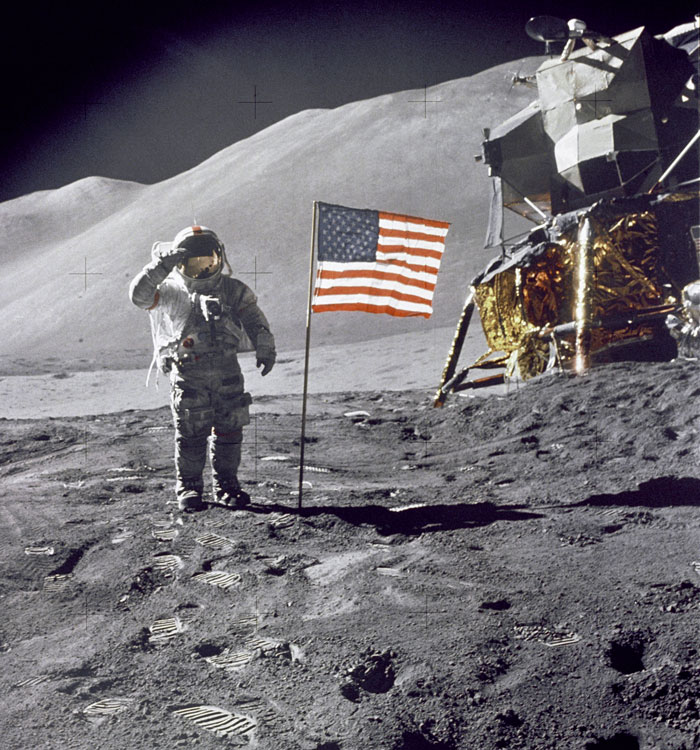 Astronaut saluting an American flag that was placed on the surface of the moon.