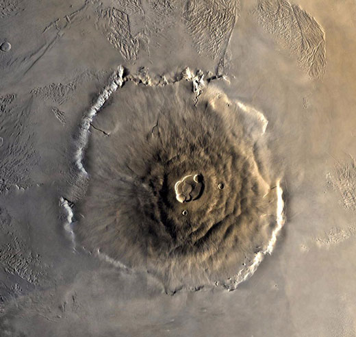 Aerial view of a mountain on the martian surface. It lookslike a large circle with a crater on the top.