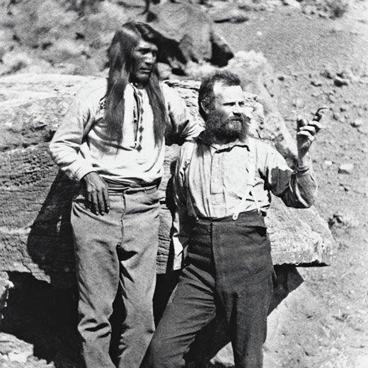 John Wesley Powell stands next to a Native American man. 