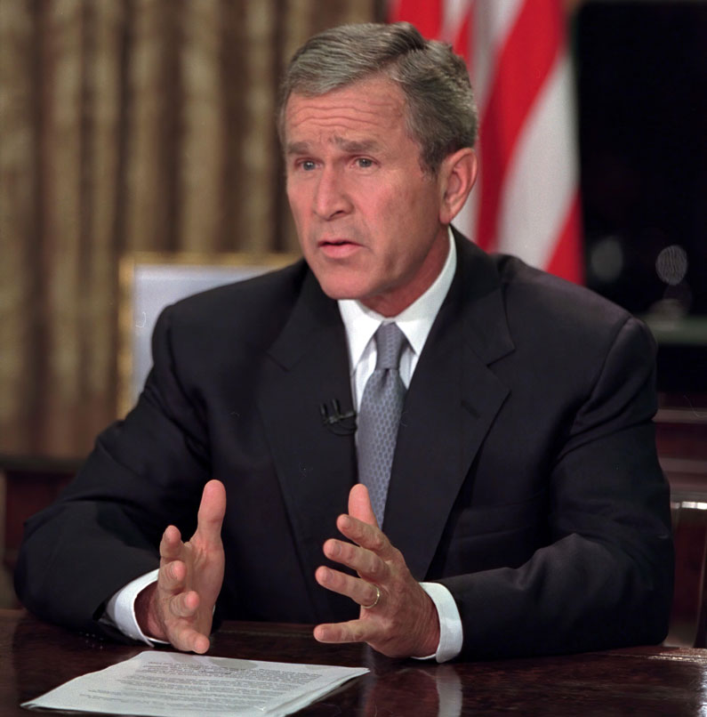 President George W Bush sitting at a desk.