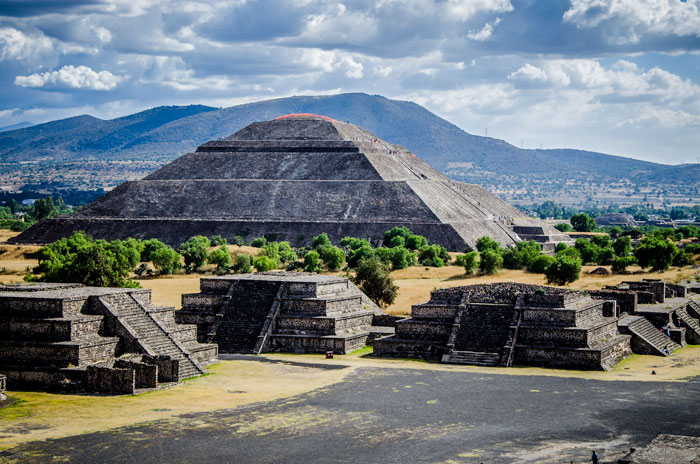 Temple called Pyramid of the Sun sits with smaller temples around it. They are all made of stone.