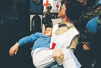 Medical worker carrying an injured child.