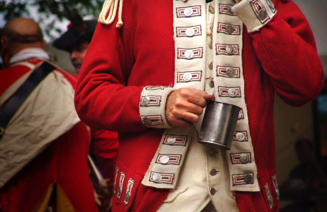 Closeup of a British soldier holding a mug.
