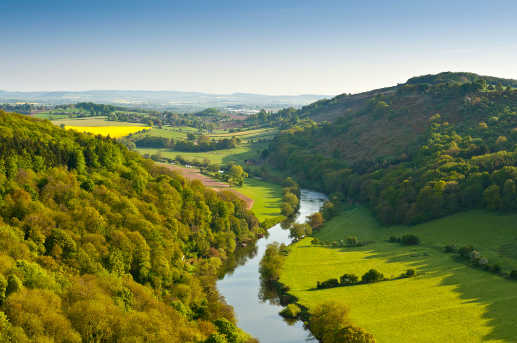 Picturesque valley showing the locations of the natural resources air, soil, water, and trees.