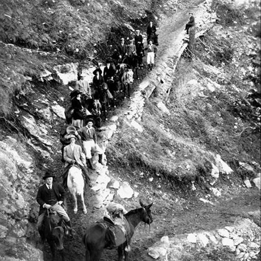 President Theodore Roosevelt and many other people ride through the canyon on horseback.