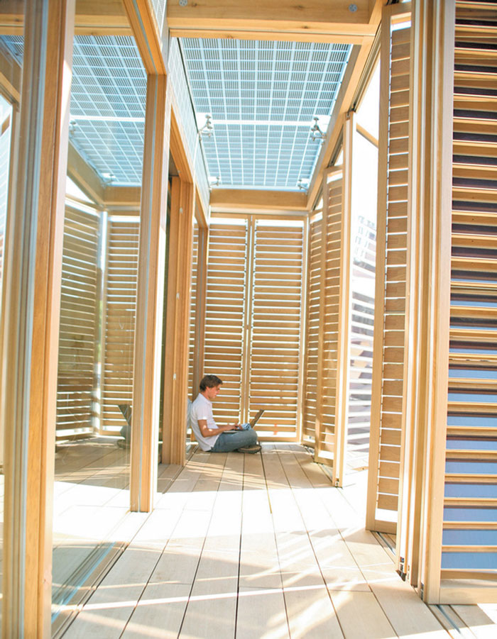 Person sitting on the floor in a house with large windows and a lot of sunlight coming it.