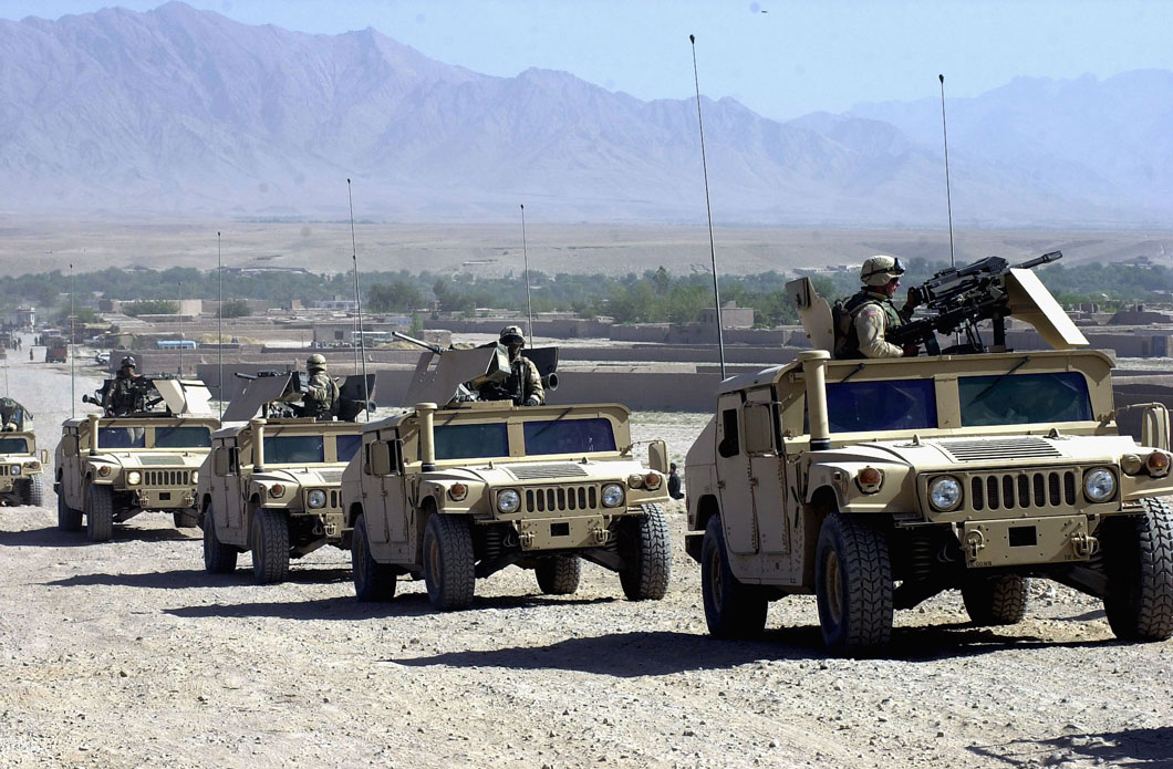 A convoy of Humvees with mounted guns and uniformed U.S. soldiers.