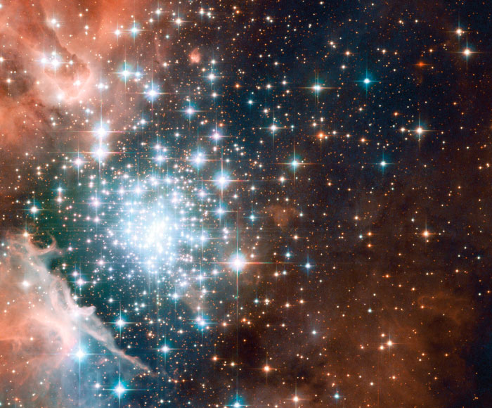 Large cluster of stars, close to each other of different colors and sizes.