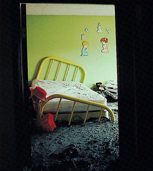 Bedroom with a broken bed caused by thick mud on the floor.