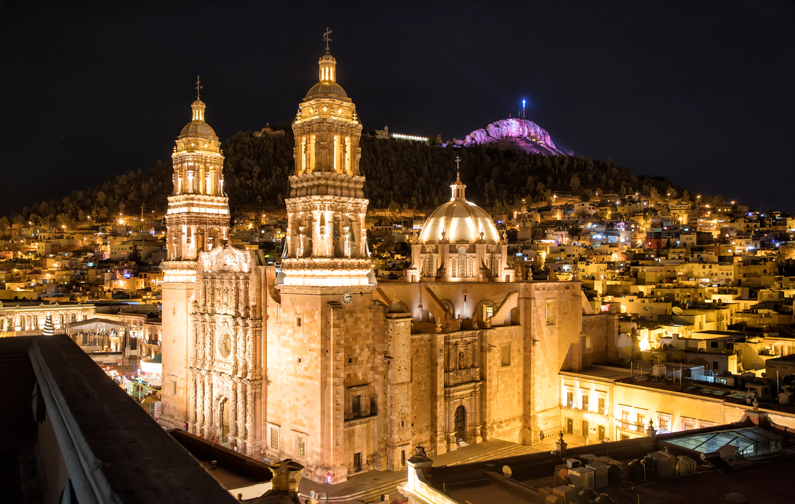 Church with domed parts of its roof lit up at night. 