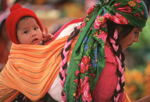 Woman carrying a baby on her back in a rebozo.