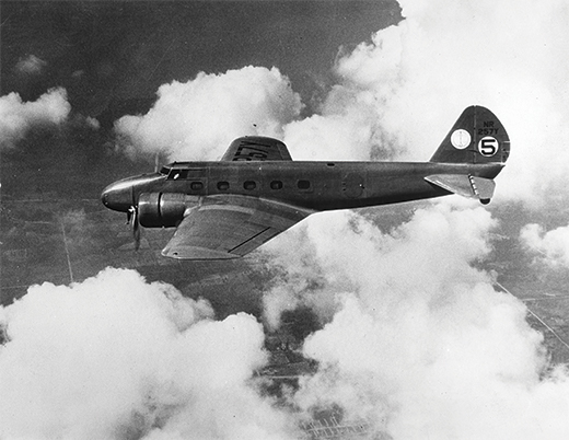 Airplane with propellers on its wings flies in the clouds.