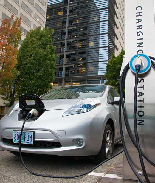 Electric car is plugged in while parked on the street.