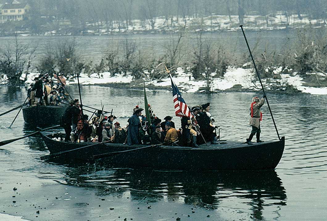 Reinactment of boats crossing the Deleware River. Soliders wearing period clothing in the boats.
