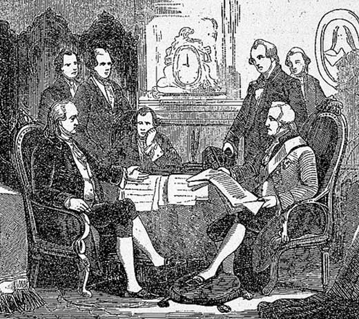 Men sitting at a table looking over papers.