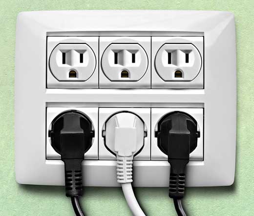 Wall outlet with three plugs plugged into it.