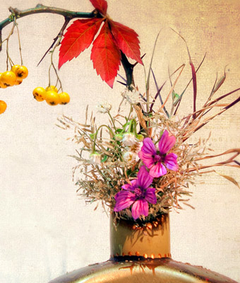 Vase filled with flowers and other plants.