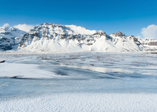 Mountains and vast expanse of land with snow on them. 